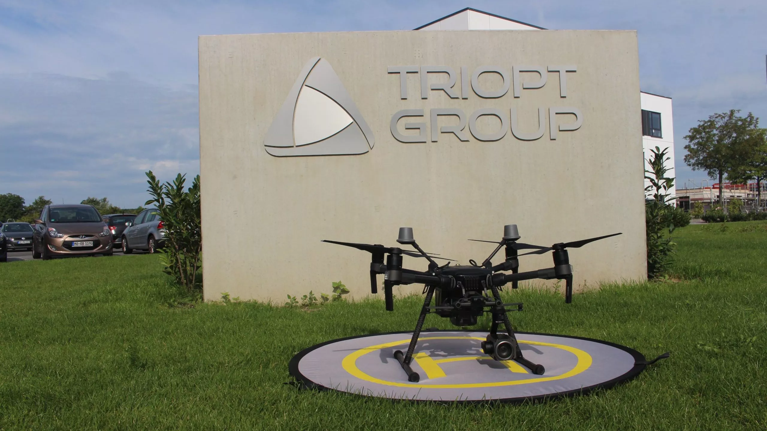 Drohne vor Triopt Group Schild