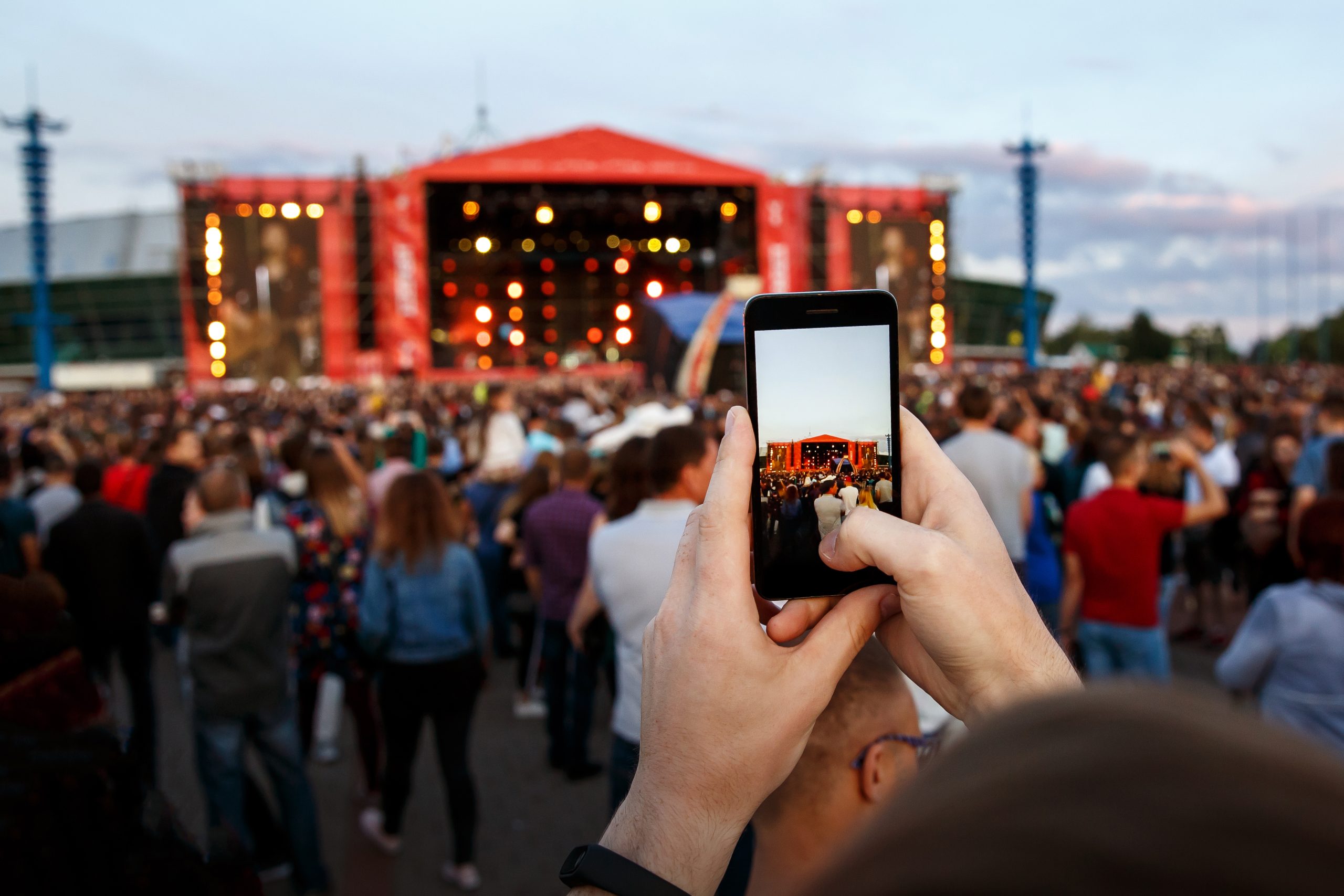 Hand mit Smartphone nimmt Musik Festival auf
